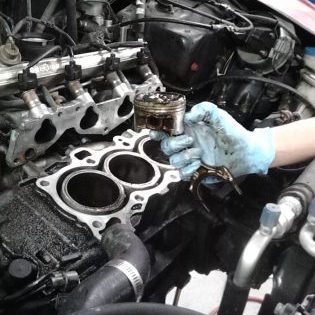 engine repair in progress, with piston removed from four cylinder